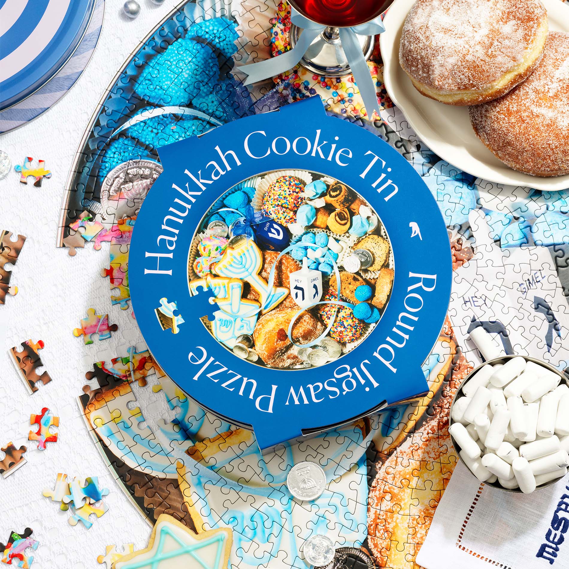 http://pieceworkpuzzles.com/cdn/shop/files/hanukkah-cookie-tin-750-piece-round-jigsaw-puzzle-piecework-puzzles-2.jpg?v=1696637505