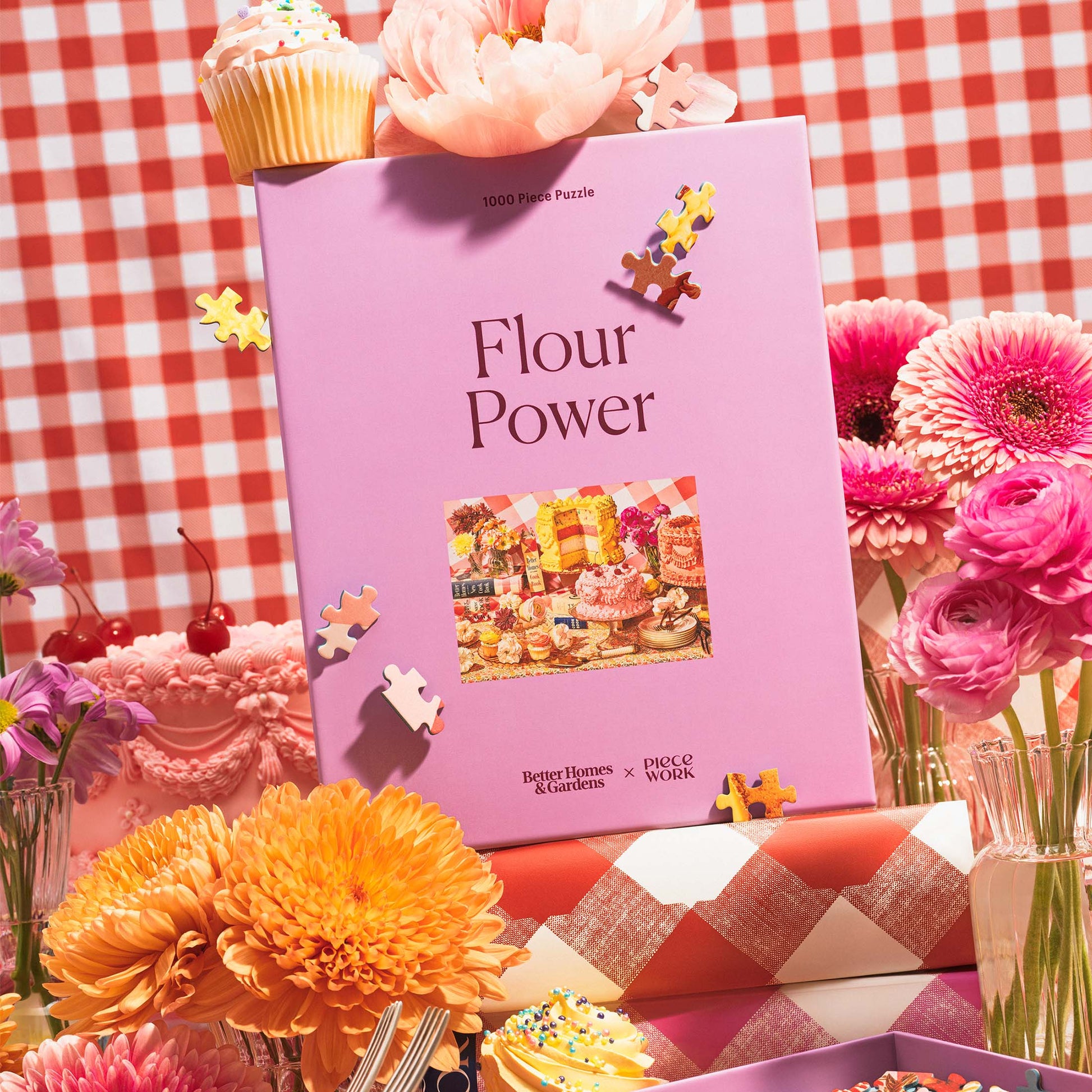Pink 'Flour Power' puzzle box with flowers and cupcakes on a checkered tablecloth