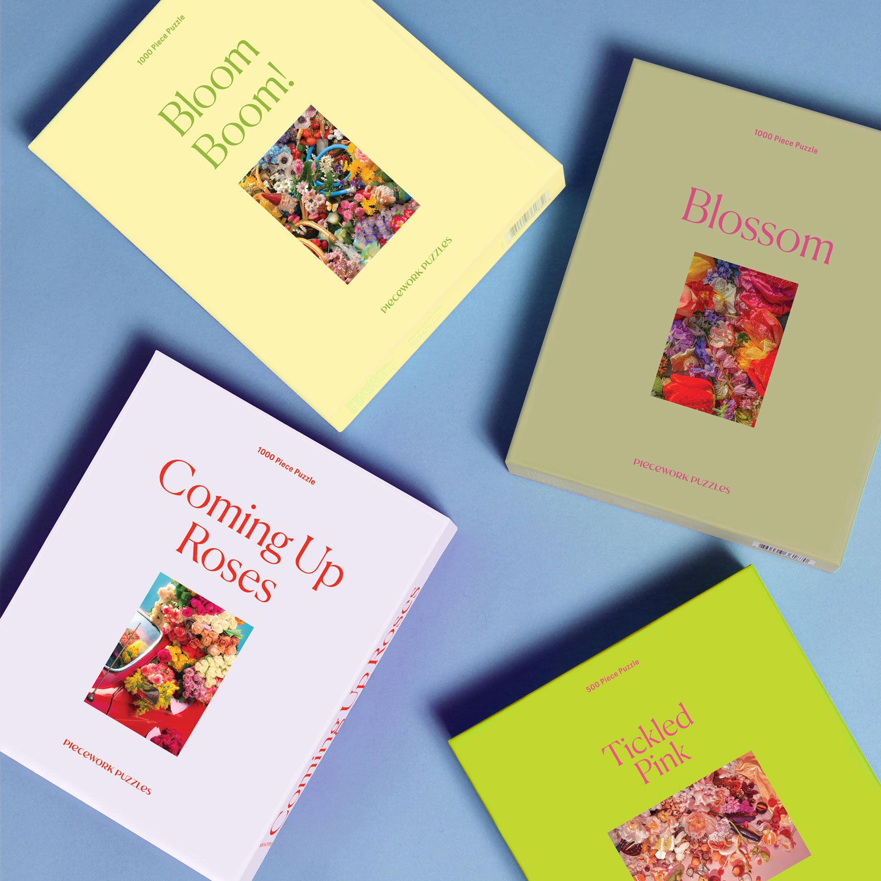 Four flower puzzle boxes on a blue surface.