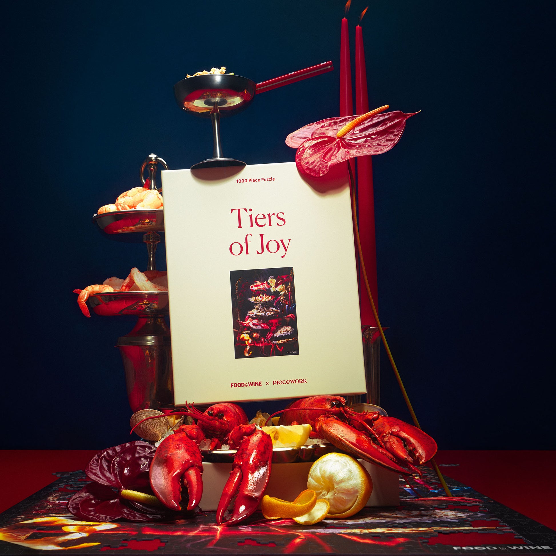 Piecework x Food & Wine's puzzle titled 'Tiers of Joy,' shown with red taper candles and a tiered seafood tower on a dark background.