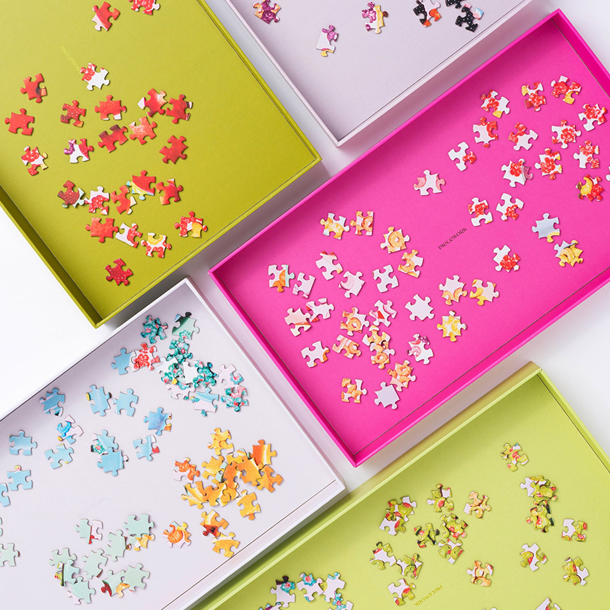 Piecework's puzzle sorting trays shown in arranged side-by-side on a white seamless background with puzzles pieces in each of the six trays.