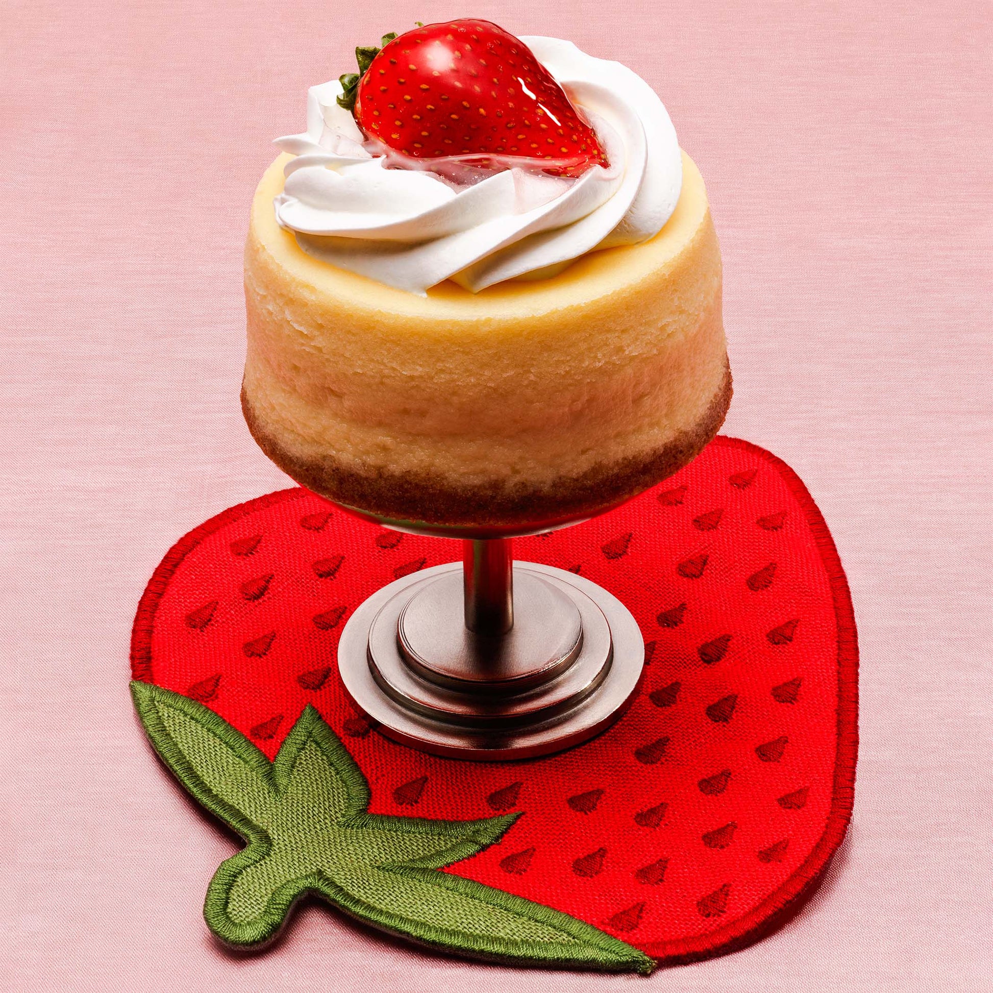A strawberry dessert displayed on a strawberry-shaped embroidered linen napkin by Piecework.