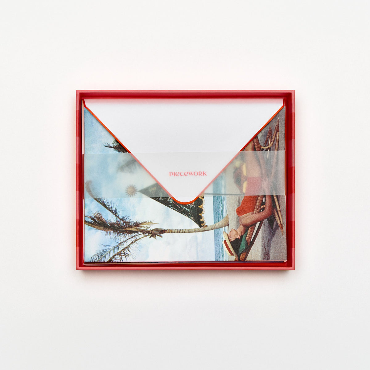 Piecework Palm Beach Idyll Stationery Set: open coral-striped box of beach palm notecards and envelopes under a vellum band