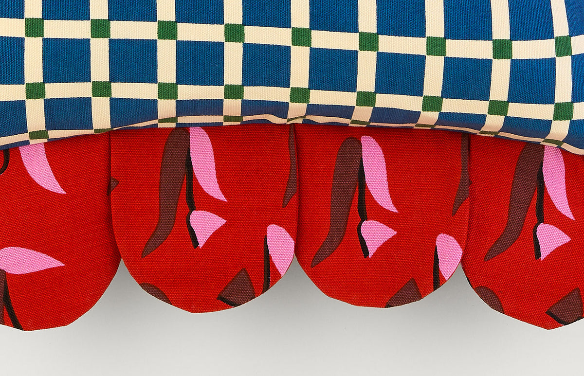 Close-up of the Blue Window Petal Pillow: blue windowpane check above a red tulip-print petal edge