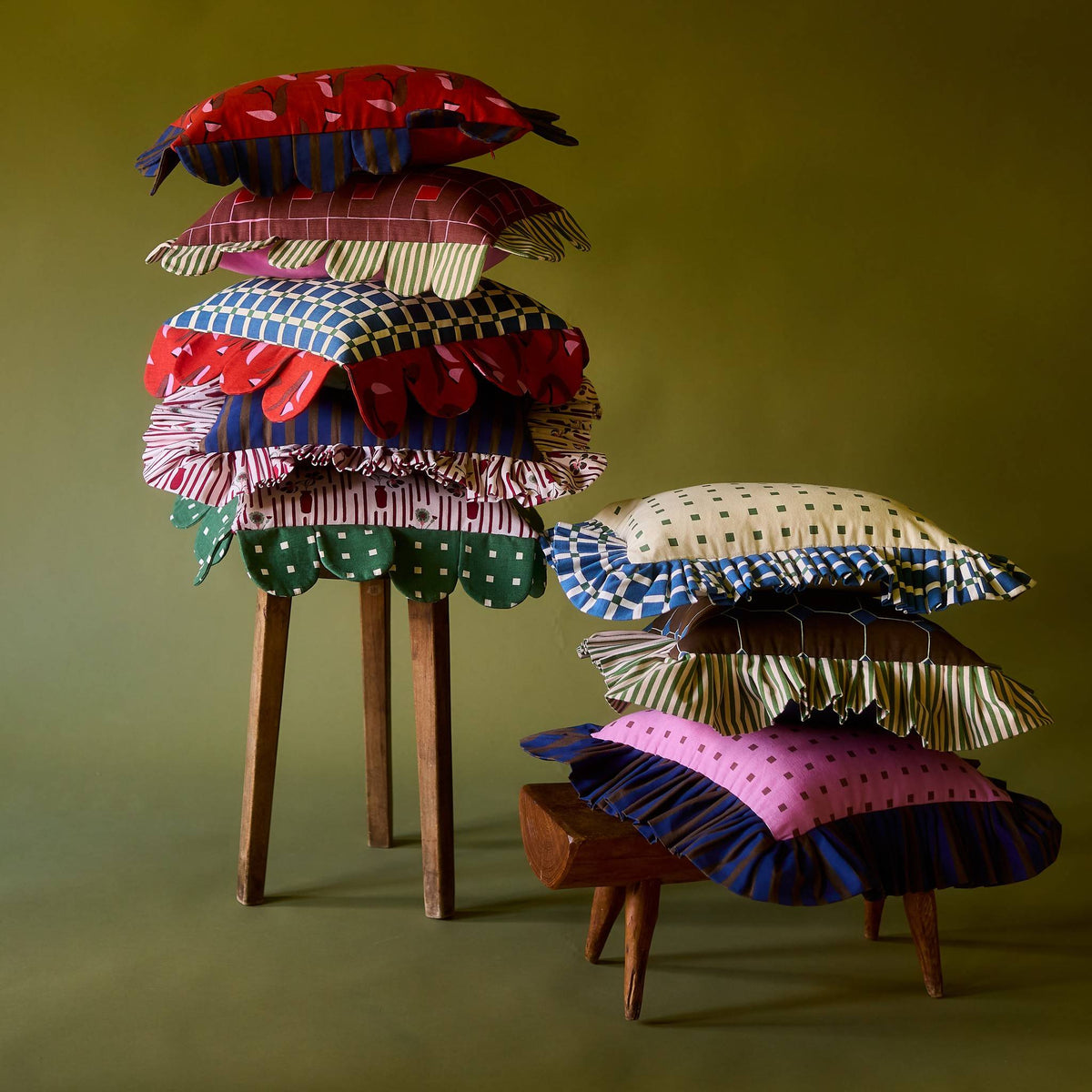 Blue Window Petal Pillow stacked with Piecework pillows on wooden stools