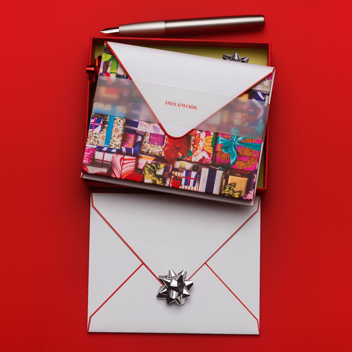Piecework Fa La La La La Stationery Set: open red box of notecards over an envelope with a silver bow on red