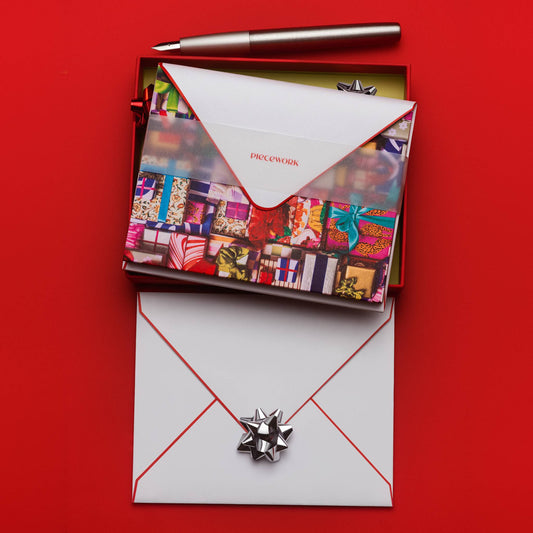 Piecework Fa La La La La Stationery Set: open red box of notecards over an envelope with a silver bow on red