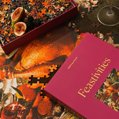 A close-up view of the Feastivities puzzle in progress reveals a roasted turkey among rich holiday food imagery. The puzzle box and fig halves rest nearby.
