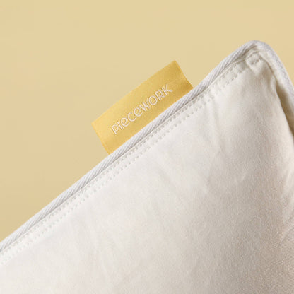 Feather Pillow Insert corner with white cotton shell and Piecework label