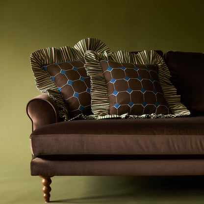 Two Jewel Stripe Ruffle Pillows on a brown velvet sofa