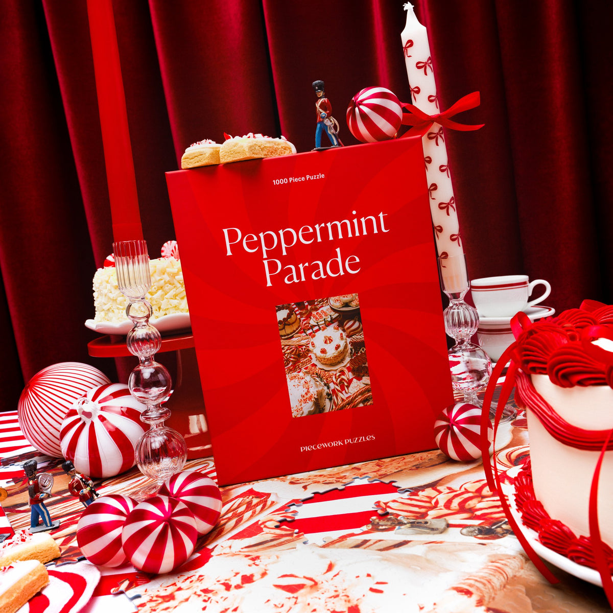 Peppermint Parade 1000-piece puzzle box among peppermint candies, layer cakes, a striped candle and a toy soldier