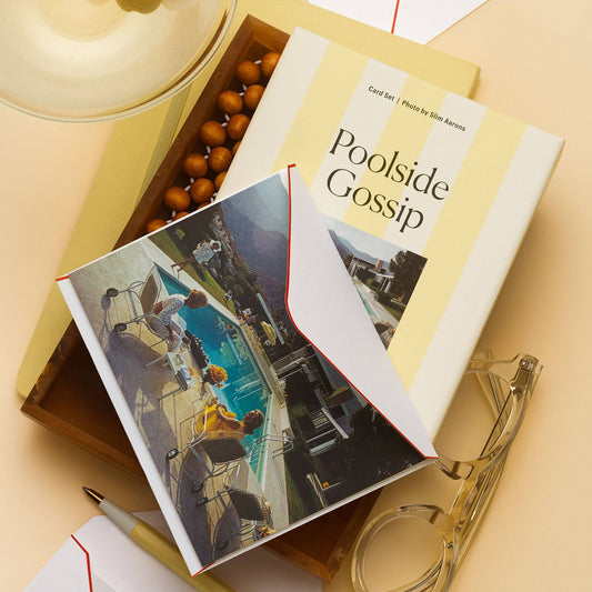 Piecework Poolside Gossip Stationery Set: yellow-striped box and Slim Aarons notecard in a wood tray beside a martini