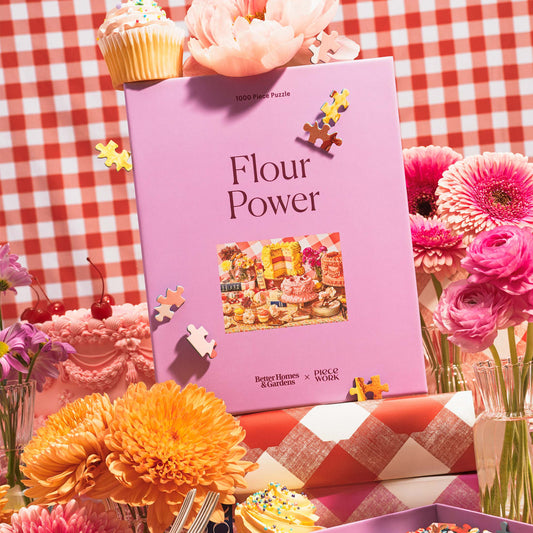 Pink 'Flour Power' puzzle box with flowers and cupcakes on a checkered tablecloth