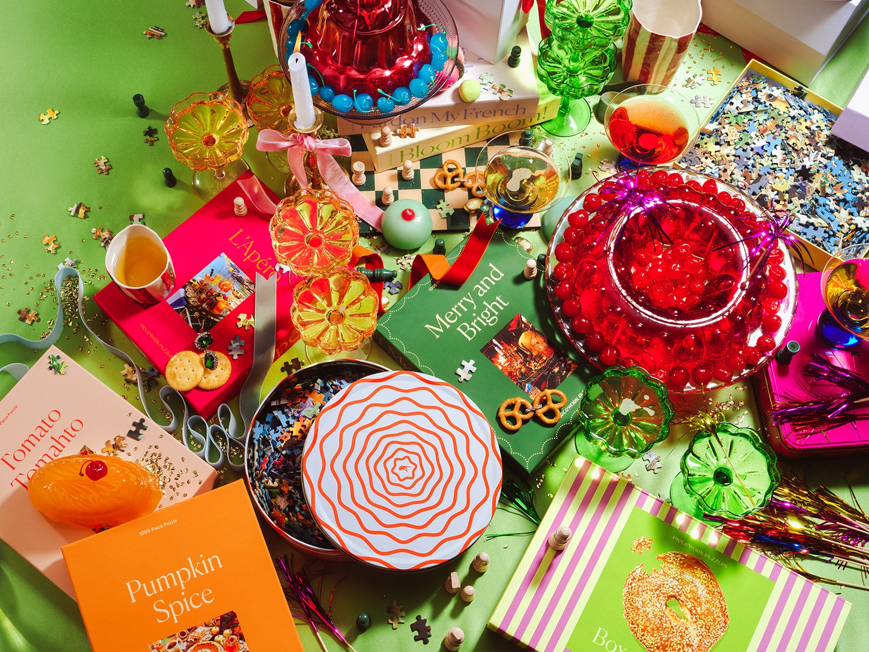 An image of a festive scene of holiday puzzles, treats and decor.