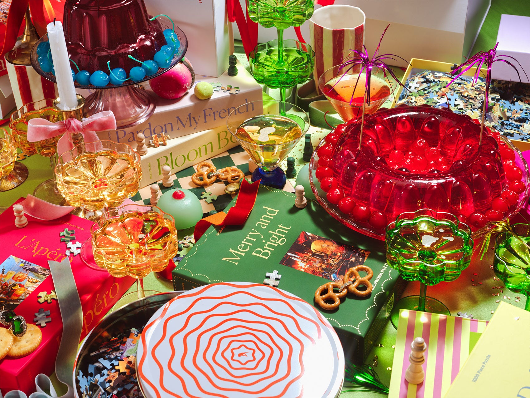 A table scene of Piecework Puzzles puzzle boxes and festive cocktails and decorations.