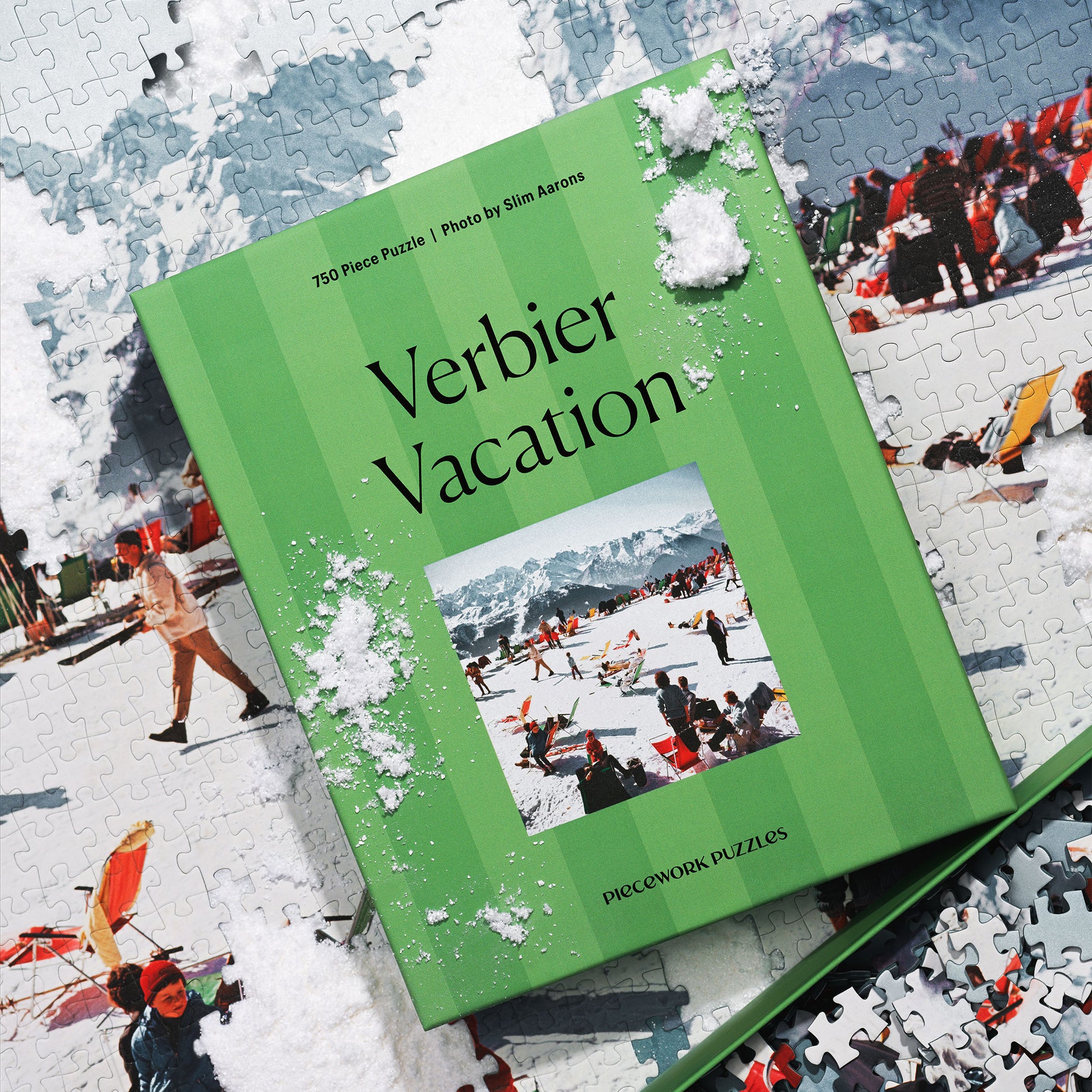 Jigsaw puzzle box titled 'Verbier Vacation' shown on top of the assembled puzzle, a vintage, snowy vacation scene.