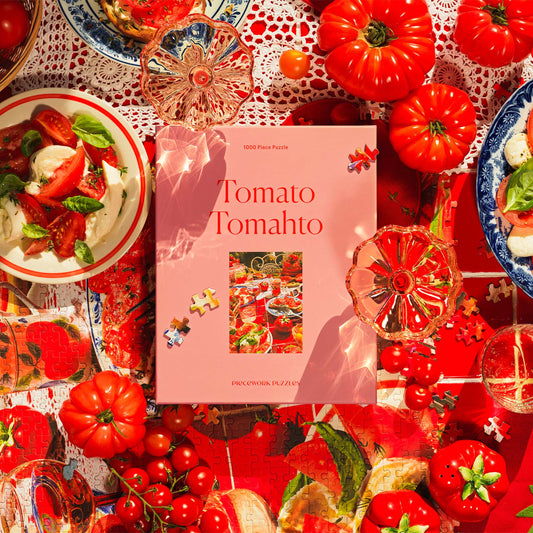 Tomato Tomahto, a 1000-piece jigsaw puzzle from Piecework Puzzles, on a red-tiled surface and surrounded by tomatoes and puzzle pieces.