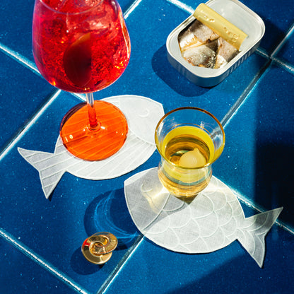 Two Sardine Napkins on a blue tile counter top accompanied by drinks.