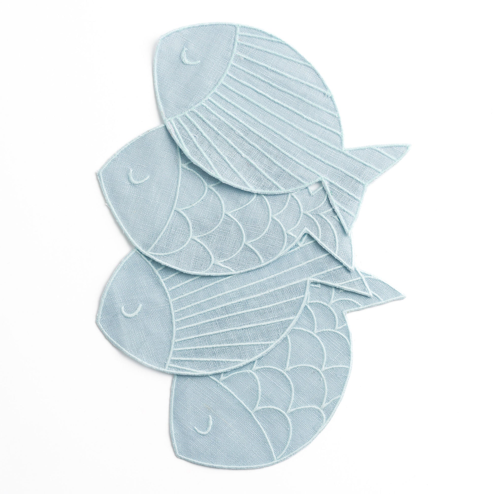 A set of four fish-shaped "sardine" linen napkins in a pale blue on a white seamless background. The four napkins are arranged overlapping.