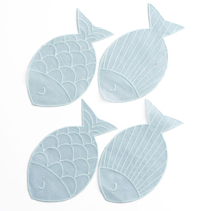 A set of four fish-shaped "sardine" linen napkins in a pale blue on a white seamless background. The four napkins are arranged separated and "swimming downward".