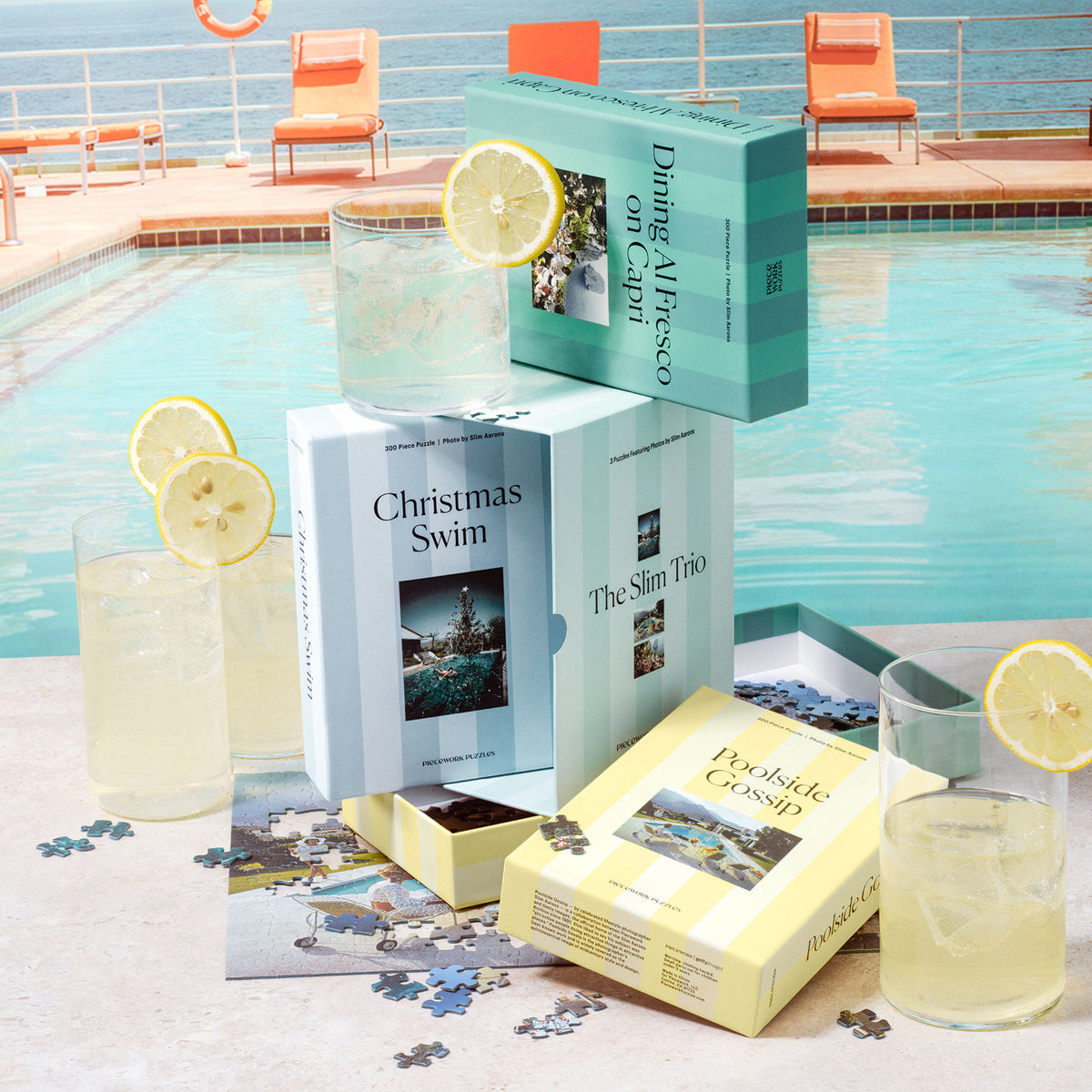 Slim Aarons Trio Set puzzle boxes arranged poolside next to lemonade and loose puzzle pieces