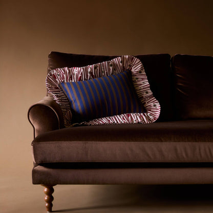 Striped Posie Ruffle Pillow on a brown velvet sofa