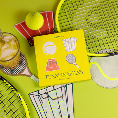 Yellow box of tennis-themed napkins with a tennis racket, ball, and drink on a neon green surface.