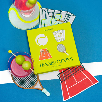 Yellow box of tennis-themed cocktail napkins with drinks on a blue surface.