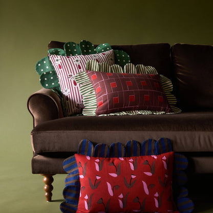 Venetian Check Petal Pillow with other Piecework pillows on a velvet sofa