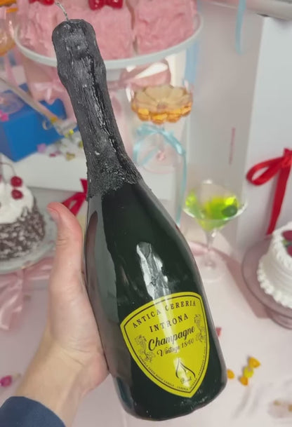 A video featuring a champagne bottle candle being held in a hand and rotated in front of the camera.