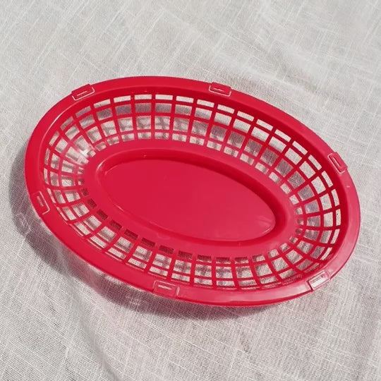 Video showing BBQ cocktail napkins being placed one-by-one in an oval red food basket.