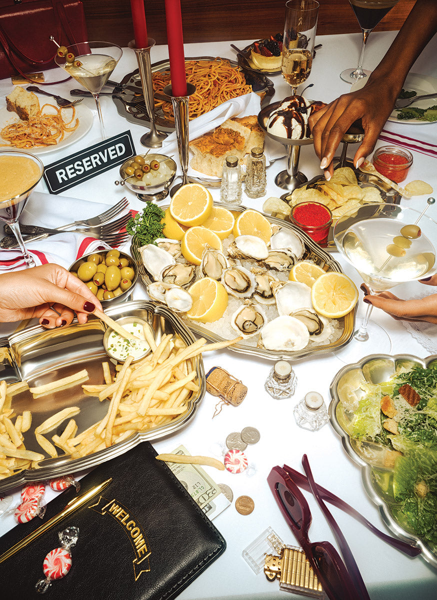 Puzzle art for 'Romaine Holiday' a 1000-piece puzzle from piecework. The art shows diverse food platters with various dishes on a table, including a 'RESERVED' sign.